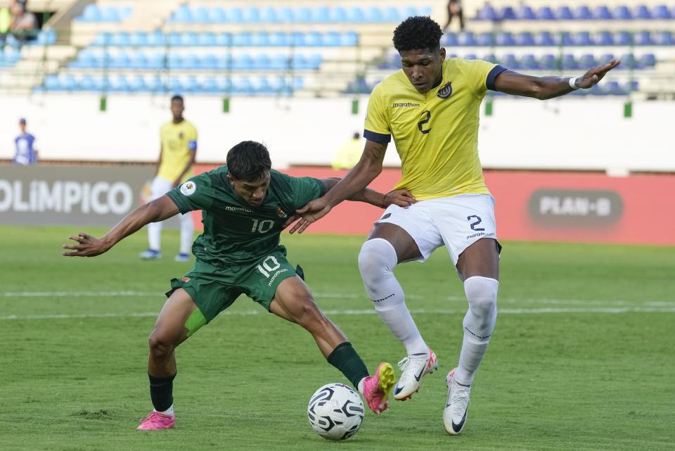 Lucas Chavez de Bolivia y Óscar Quiñónez de Ecuador pelean por el balón durante el torneo del preolímpico sudamericano sub-23 en Caracas, Venezuela el viernes 26 de enero del 2024. (AP Foto/Ariana Cubillos)