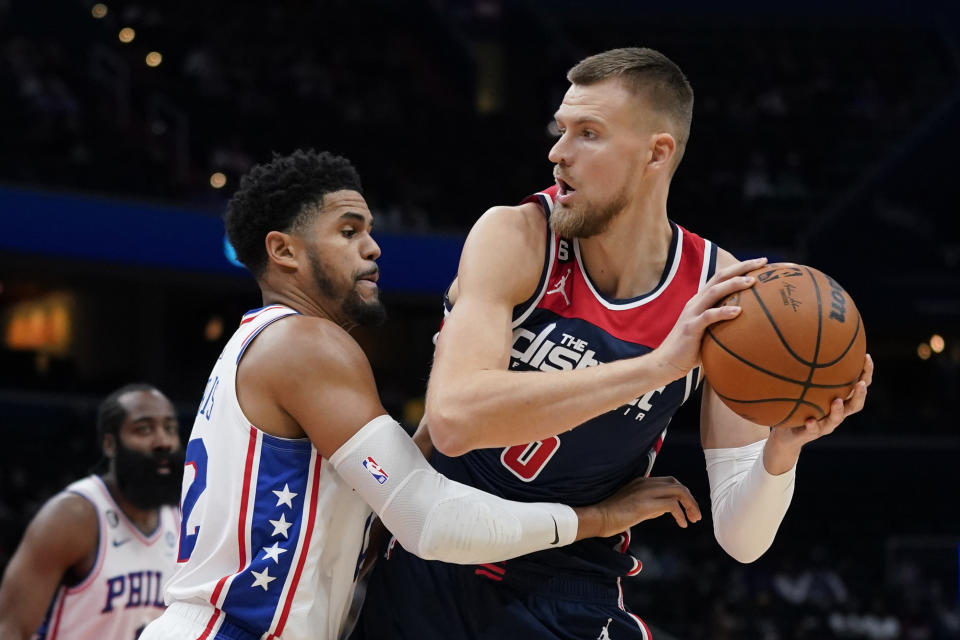 Washington Wizards center Kristaps Porzingis, right, of Latvia, protects the ball as he is pressured by Philadelphia 76ers forward Tobias Harris in the first half of an NBA basketball game, Monday, Oct. 31, 2022, in Washington. (AP Photo/Patrick Semansky)