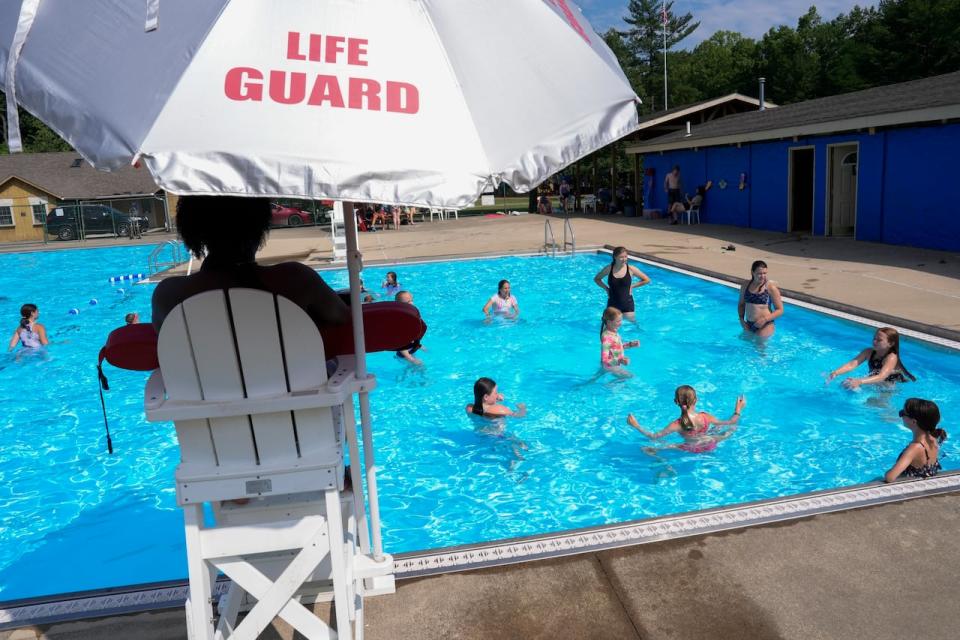 Campers swim in the pool, on June 20, at YMC Camp Kern in Oregonia, Ohio. The employment rate among returning students — those trying to find summer jobs before returning to school full-time in the fall — fell to 46.8 per cent in June.  (Joshua A. Bickel/The Associated Press - image credit)