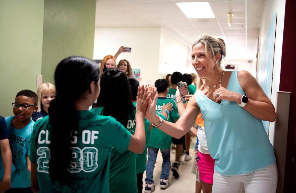Palm Beach Public principal Christie Schwab cheers on fifth grade students as they do their final hallway walk on the last day of school Friday May 26, 2023 in Palm Beach. 