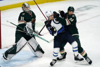 Minnesota Wild's Matt Dumba (24) ties up Winnipeg Jets' Nikolaj Ehlers (27) as he helps goalie Cam Talbot, left, defend the net in the first period of an NHL hockey game, Friday, Nov. 26, 2021, in St. Paul, Minn. (AP Photo/Jim Mone)