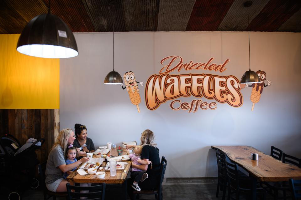 A group of friends and their kids eat at Drizzled Waffles and Coffee restaurant at 3061 North Main St. in Hope Mills.