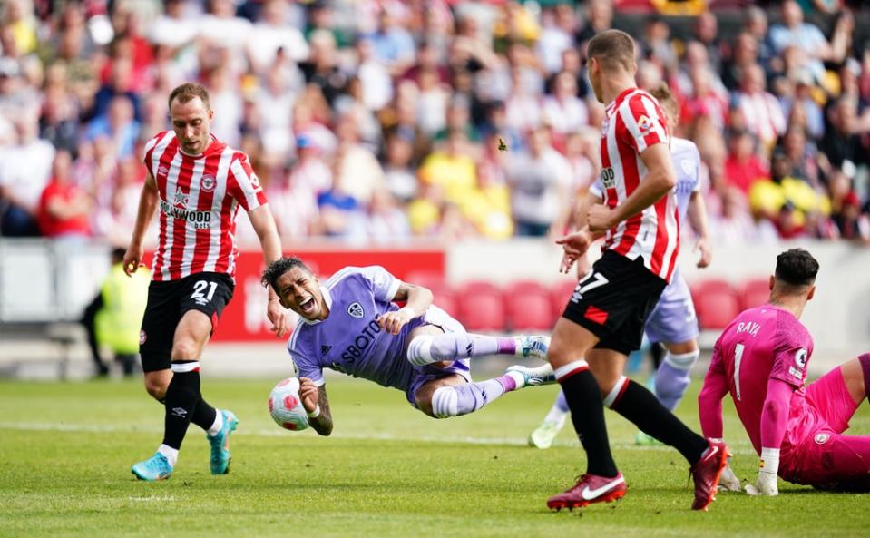 Raphinha is challenge by goalkeeper David Raya (PA)