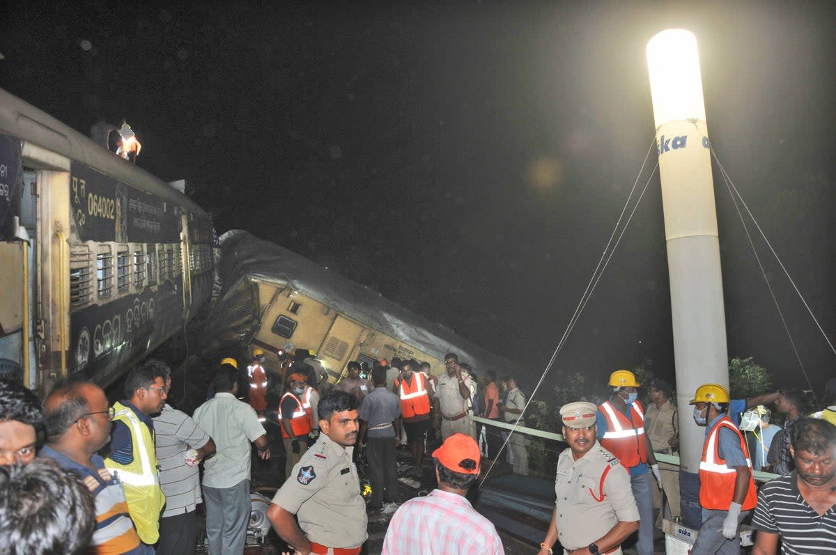 Rescuers and others stand after two passenger trains collided in Vizianagaram district, Andhra Pradesh state (AP)