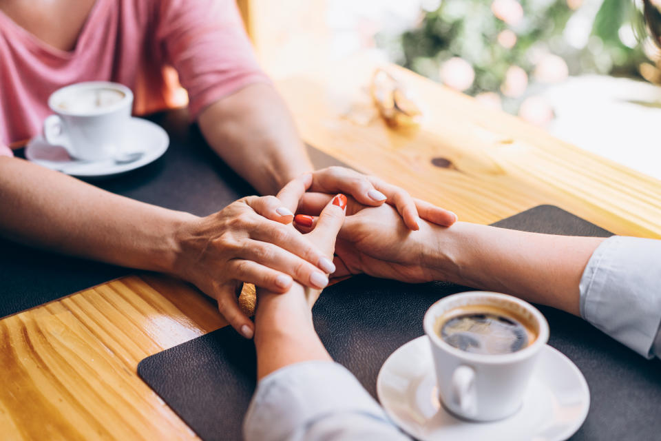 two people holding hands with coffee