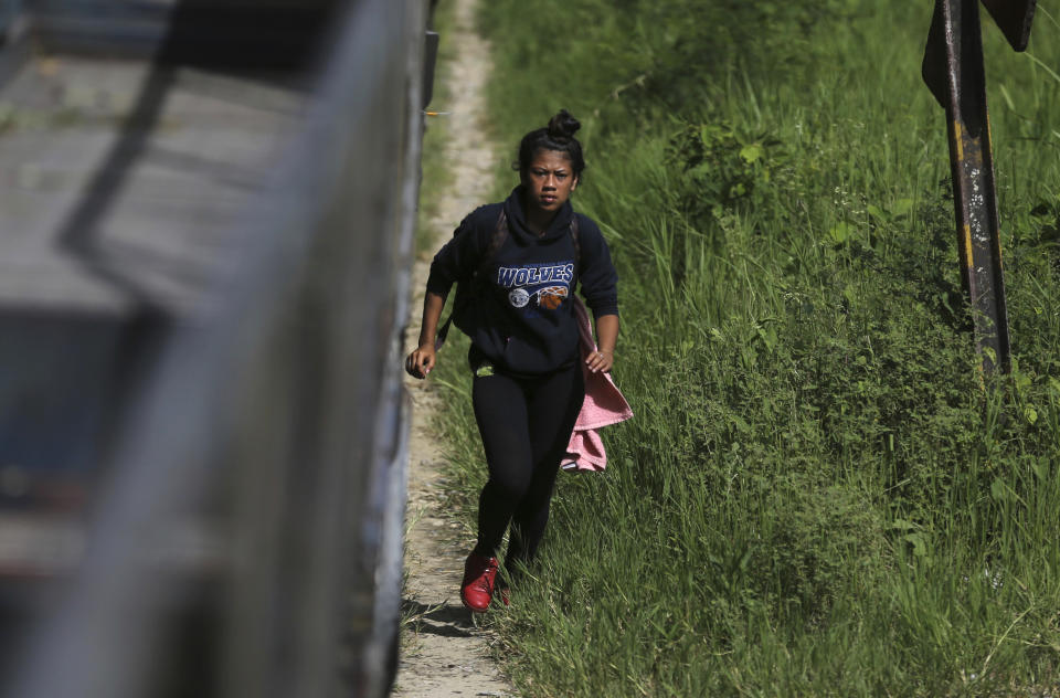 In this June 25, 2019 photo, 19-year-old Honduran Saily Yasmín Andino runs to climb aboard a freight train, near Salto de Agua, Mexico. Hours later the train stopped near the Tabasco state town of Tacotalpa and Andino hopped off to buy some cheese-stuffed rolls. When the train crowded with migrants began to move again, she hustled to clamber back aboard. But the train suddenly stopped and rolled back. She lost her grip and fell beneath its wheels. (AP Photo/Marco Ugarte)