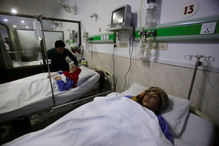 A relative cares for a woman injured during shelling along the disputed border between Pakistan and India at CMH hospital in Sialkot, Pakistan September 22, 2017. REUTERS/Mohsin Raza