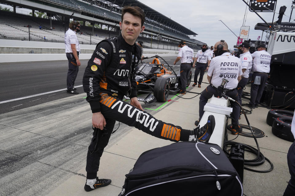 Pato O'Ward, of Mexico, stretches during practice for the Indianapolis 500 auto race at Indianapolis Motor Speedway, Wednesday, May 19, 2021, in Indianapolis. (AP Photo/Darron Cummings)