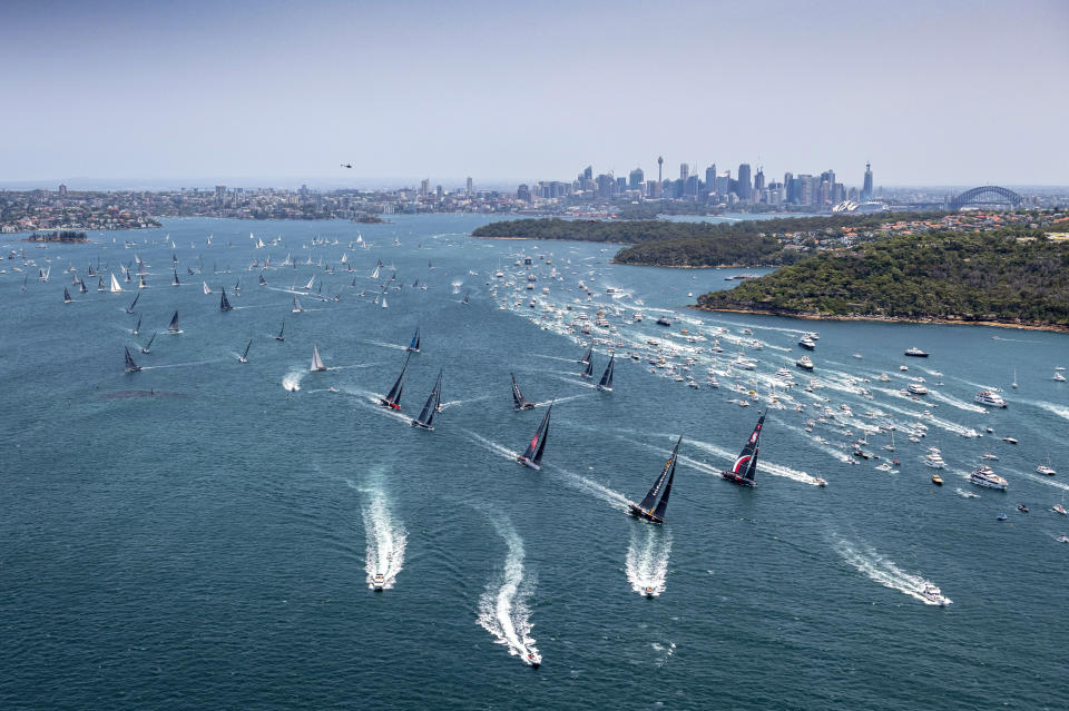 Competitors and the spectator fleet, right, race along at start of the 75th Sydney Hobart yacht race in Sydney Harbour, Thursday, Dec. 26, 2019. (Rolex/Kurt Arrigo via AP)