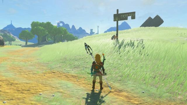 Addison struggles to hold up a sign on the green rolling hills of Hyrule.