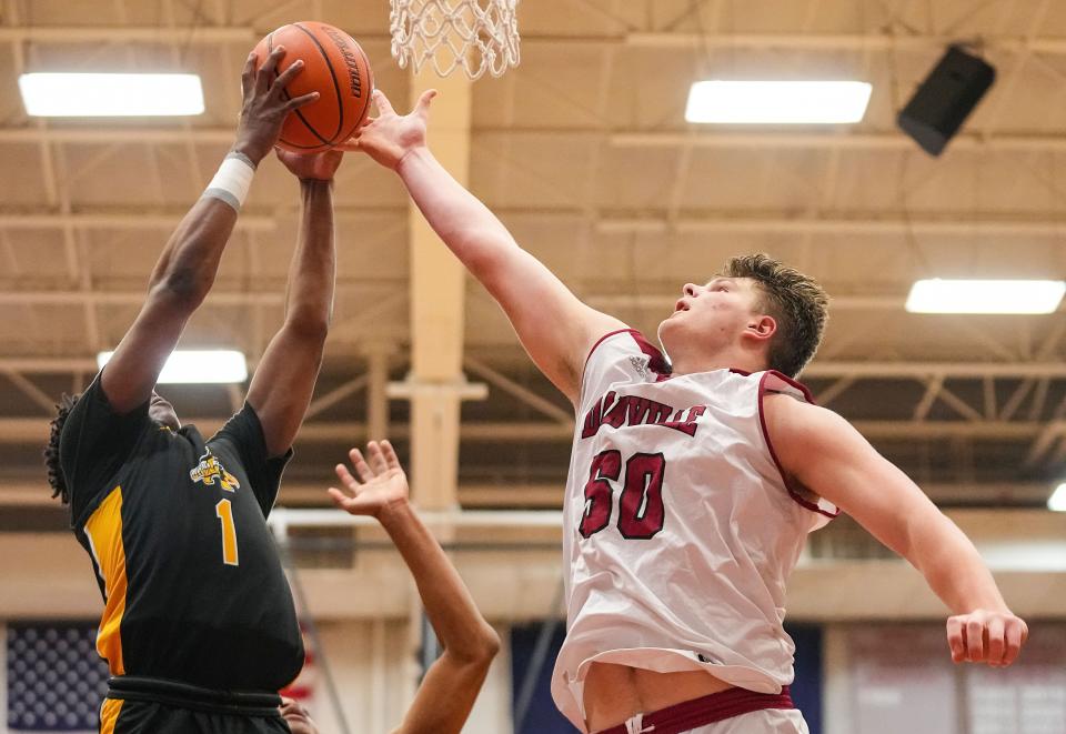 Danville's center Evan Lawrence (50) reaches to block Avon Orioles guard Rohan Pearson (1) on Saturday, Jan. 6, 2024, during the game at Danville Community High School in Danville.