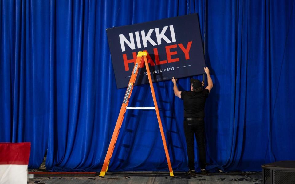 Workers hang a sign during an election night watch party for Nikki Haley