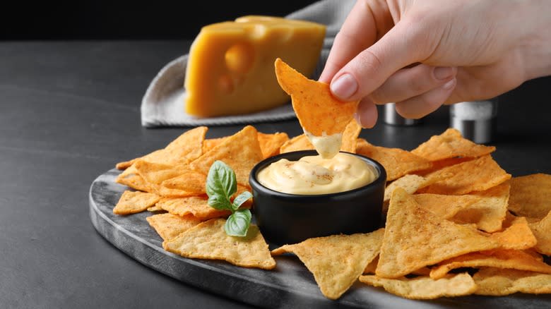 tortilla chips and queso dip, hand