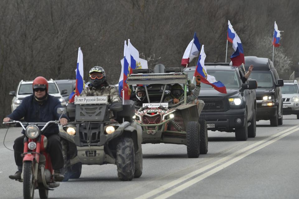 Members of the Russian biker group Nochniye Volki (the Night Wolves) drive with Russian national flags toward Sevastopol attending a motor rally marking the ninth anniversary of Crimea annexation from Ukraine, Crimea, Saturday, March 18, 2023. (AP Photo)