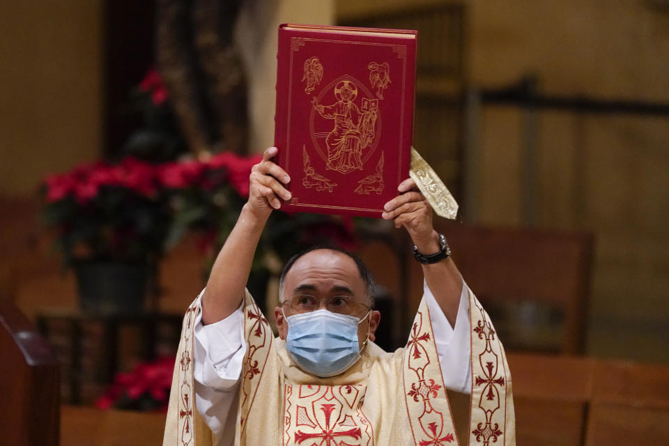 Father David Gallardo leads Christmas Eve Mass at Cathedral of Our Lady of the Angels, Thursday, Dec 24, 2020, in Los Angeles. California became the first state to record 2 million confirmed coronavirus cases, reaching the milestone on Christmas Eve as nearly the entire state was under a strict stay-at-home order and hospitals were flooded with the largest crush of cases since the pandemic began. (AP Photo/Ashley Landis)