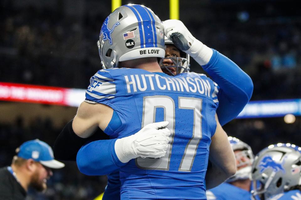 Lions defensive end Aidan Hutchinson hugs offensive tackle Penei Sewell during warmups before the NFC wild-card game at Ford Field on Sunday, Jan, 14, 2024.