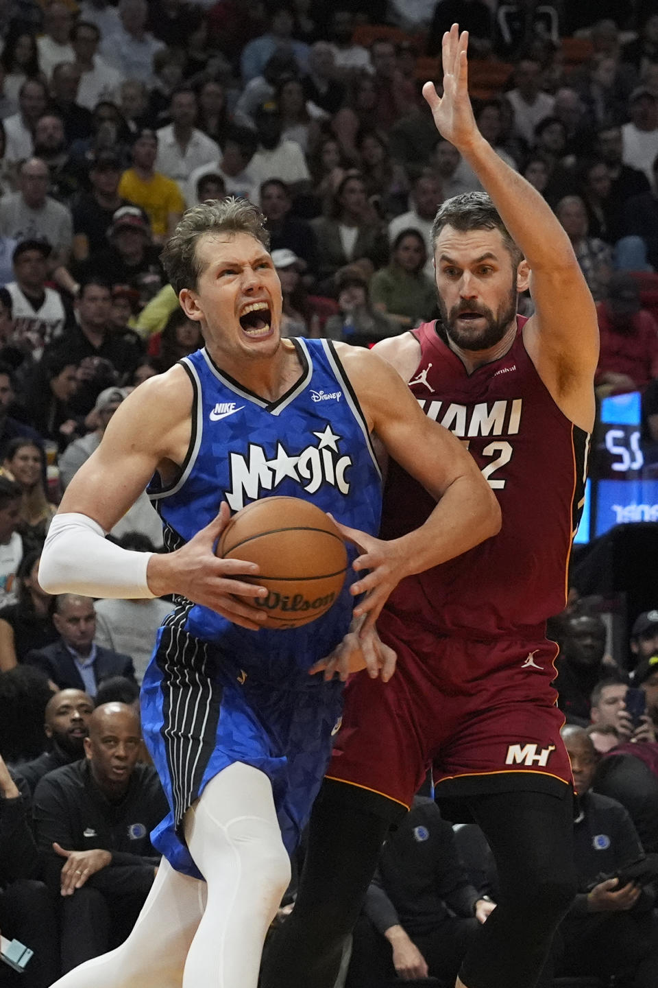 Orlando Magic center Moritz Wagner (21) drives to the basket as Miami Heat forward Kevin Love (42) defends during the first half of an NBA basketball game, Friday, Jan. 12, 2024, in Miami. (AP Photo/Marta Lavandier)