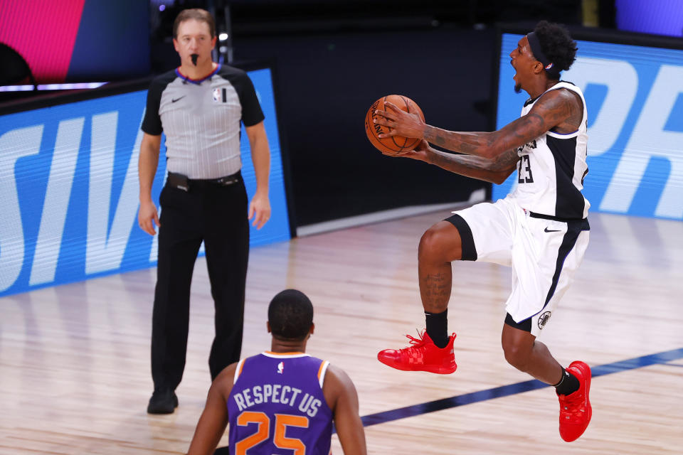 Lou Williams, right, of the Los Angeles Clippers takes a shot against the Phoenix Suns during an NBA basketball game Tuesday, Aug. 4, 2020, in Lake Buena Vista, Fla. (Kevin C. Cox/Pool Photo via AP)