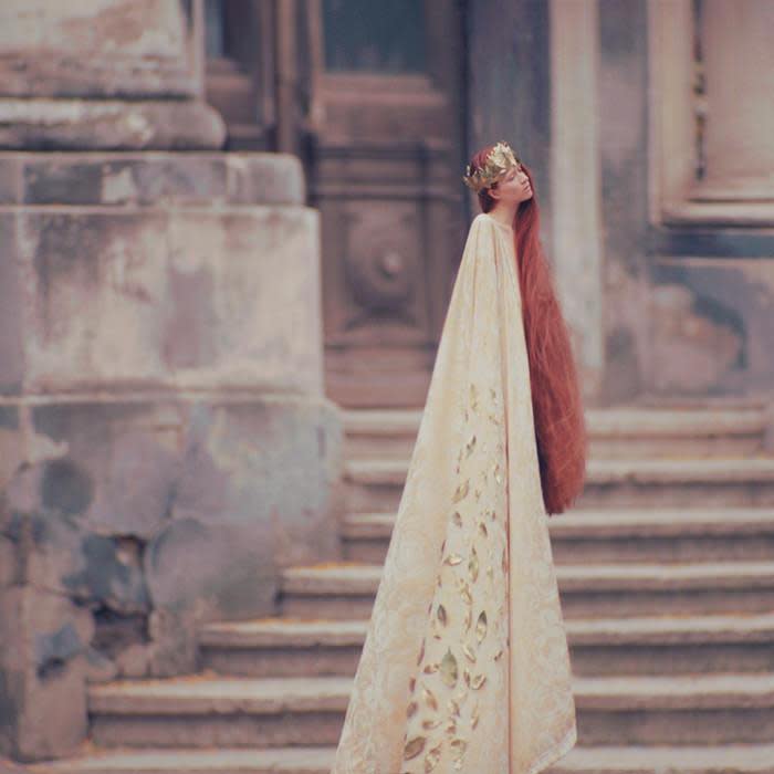 Surreal photograph by Ukrainian artist Oleg Oprisco shows a woman standing in front of classical Ukrainian architecture.