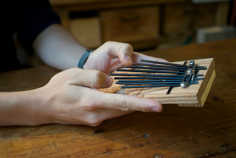 Kevin Cheung, an upcycling product designer, holds a "Glory to Hong Kong" thumb piano that he made using the ribs of umbrellas left over from protests this summer, in Hong Kong