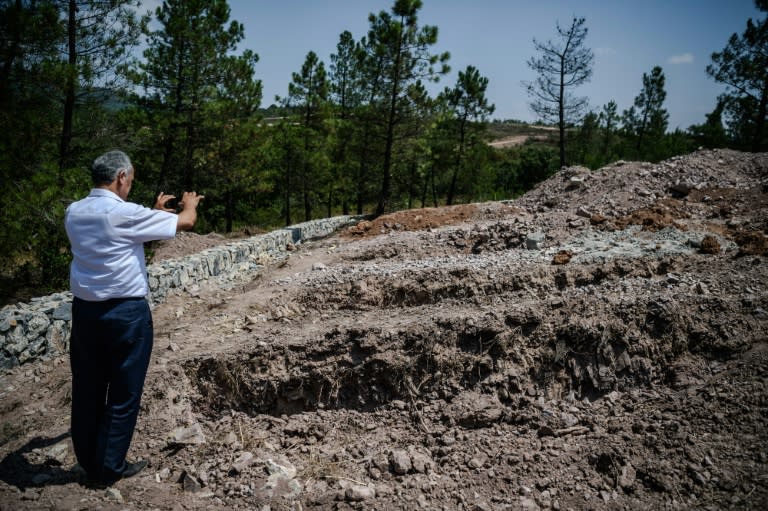 A man takes pictures of unmarked graves at "Traitors' graveyard" a barren plot of land selected for the burial of Turkish soldiers who took part in a failed coup