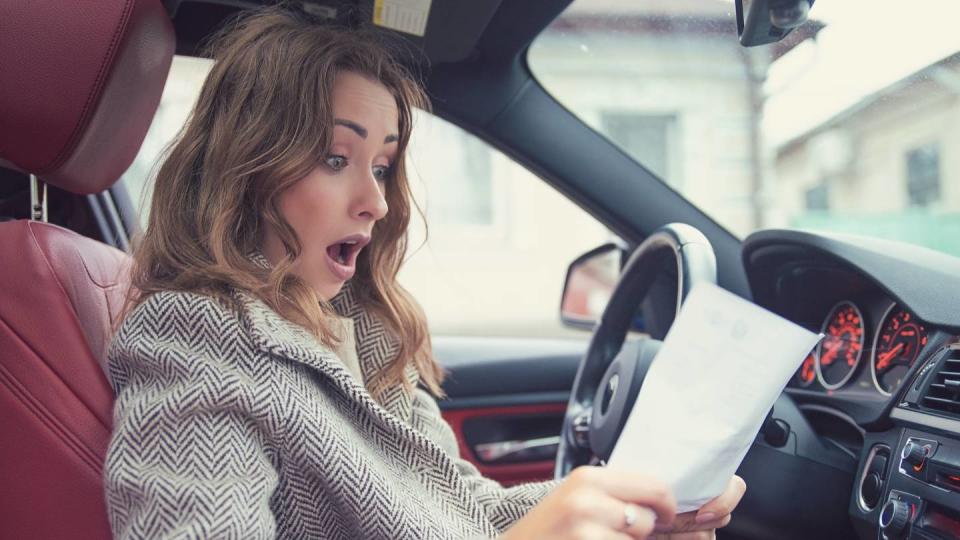 Femme lisant une facture au volant