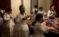 En esta imagen del 30 de abril de 2019, las actrices Carmen Aranibar, en el centro, y María Luque, a la izquierda, de la compañía de teatro "Kory Warmis" or Mujeres de oro, preparan su actuación en una obra titulada "Kusisita", en un vestuario del Teatro Municipal en La Paz, Bolivia. (AP Foto/Juan Karita)