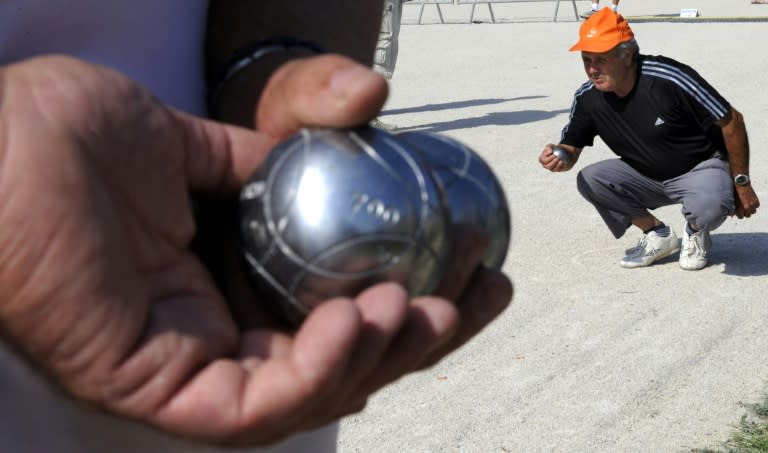 Players of petanque compete to throw steel balls closest to a smaller ball, known as the jack