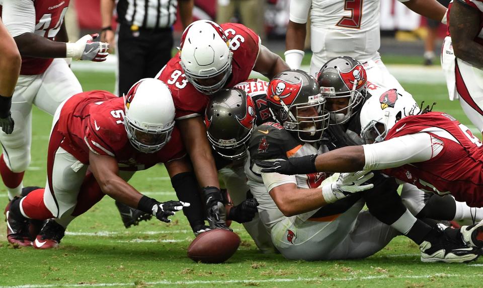 <p>Defensive tackles Ed Stinson #91 (right), Calais Campbell #93 and linebacker Kevin Minter #51 of the Arizona Cardinals pounce on a loose ball over center Joe Hawley #68 and tight end Austin Seferian-Jenkins #87 of the Tampa Bay Buccaneers during the second quarter of the NFL game at University of Phoenix Stadium on September 18, 2016 in Glendale, Arizona. (Photo by Norm Hall/Getty Images) </p>