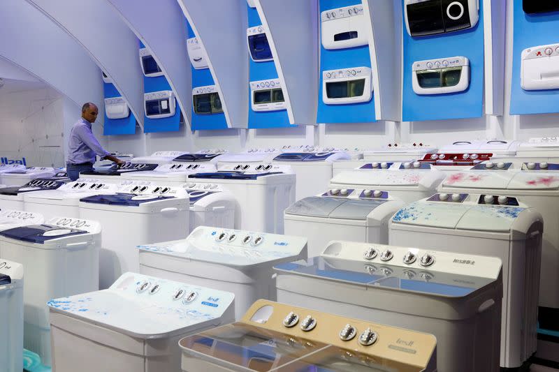 FILE PHOTO: A visitor checks a washing machine during the China Import and Export Fair, also known as Canton Fair, in the southern city of Guangzhou