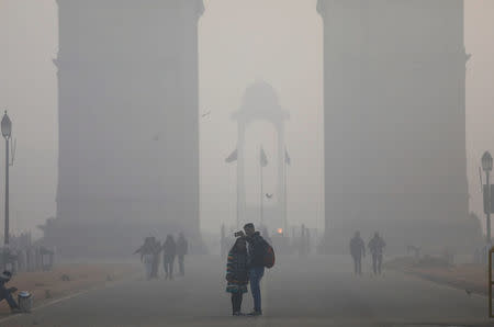 FILE PHOTO: People take a selfie in front of the India Gate war memorial on a smoggy winter morning in New Delhi, India, December 26, 2017. REUTERS/Saumya Khandelwal/File Photo