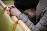 A christian faithful wearing a mask to prevent contacting coronavirus prays during a service in Seoul