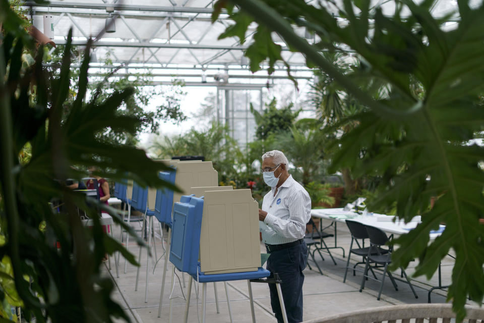 Rafael Martinez looks over his ballot while voting in the state's primary election at the Roger Williams Park Botanical Center in Providence, R.I., Tuesday, Sept. 13, 2022. (AP Photo/David Goldman)