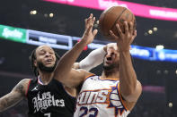 Phoenix Suns guard Eric Gordon, right, shoots as Los Angeles Clippers guard Amir Coffey defends during the first half of an NBA basketball game Wednesday, April 10, 2024, in Los Angeles. (AP Photo/Mark J. Terrill)