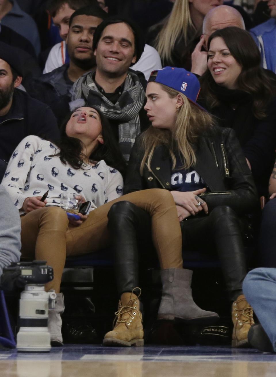 FILE - In this Tuesday Jan. 7, 2014 file photo Michelle Rodriguez, left, blows vapor from an electronic cigarette as Cara Delevingne watches during the second half of an NBA basketball game between the New York Knicks and the Detroit Pistons in New York. "Vaping,” has had astonishing growth. In just eight years or so the number of enthusiasts around the world has grown from a few thousand to millions. (AP Photo/Frank Franklin II, File)