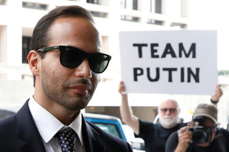 A protester holds a banner as former Trump campaign aide George Papadopoulos arrives for his sentencing hearing at U.S. District Court in Washington, U.S., September 7, 2018. REUTERS/Yuri Gripas