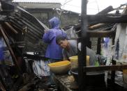 <p>Filipino villagers collect belongings inside a damaged home in the typhoon-hit town of Aparri, Cagayan province, Philippines, on Sept. 15, 2018.<br>Mangkhut, the most powerful typhoon to strike the Philippines in the last five years, made landfall in the northeastern town of Baggao with maximum sustained winds of 205 km/h (128 mph) and gusts of up to 285 km/h (177 mph). The Category 5 storm came ashore at 1:40 am (17:40 GMT on 14 September) in Cagayan province, the Philippine Atmospheric, Geophysical, and Astronomical Services Administration (PAGASA) said. Mangkhut, denoted Ompong in the Philippines, is moving west-northwest at 35 km/h and is expected to exit the archipelago in the direction of Hong Kong late Sept. 15, according to the PAGASA bulletin. Forecasters said that coastal areas in the impact zone could experience a storm surge of as much as 6 metres.<br>(Photo by Francis R. Malasig, EPA) </p>