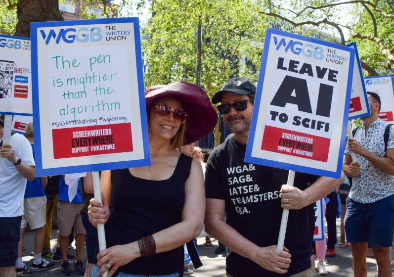 LONDON, UNITED KINGDOM - 2023/06/14: Protesters hold placards in support of writers and opposed to Artificial Intelligence (AI) replacing writers, during the demonstration. UK screenwriters and Writers' Guild Of Great Britain (WGGB) members staged a rally in Leicester Square in solidarity with striking screenwriters in the USA. (Photo by Vuk Valcic/SOPA Images/LightRocket via Getty Images)