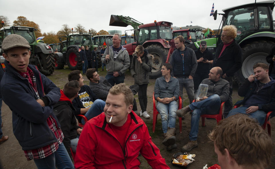 Protesting farmers gather in The Hague, Netherlands, Wednesday, Oct. 16, 2019. Thousands of Dutch farmers protest over the Netherlands efforts to drastically reduce emissions of greenhouse gases. Among the farmers' demands are that the government does not further reduce the number of animals they can keep. (AP Photo/Peter Dejong)