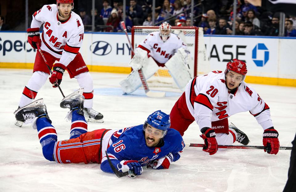 Jan 2, 2024; New York, New York, USA; New York Rangers center Vincent Trocheck (16) and Carolina Hurricanes left wing Sebastian Aho (20) fall down after a face-off during the first period at Madison Square Garden.