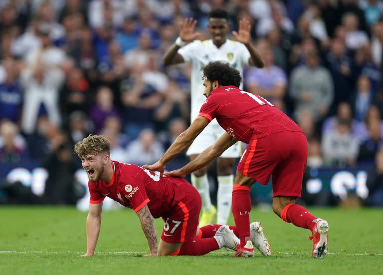 Harvey Elliott, de Liverpool, grita de dolor mientras su compañero Mohamed Salah se acerca a socorrerlo. De fondo, Júnior Firpo, de Leeds, con gesto de impresión, se da cuenta de la gravedad de la lesión