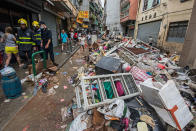 <p>Firefighters and pedestrian pass by debris after the passage of Typhoon Hato in Macau, China, Aug. 23, 2017. (Photo: Antonio Mil-Homens/EPA/REX/Shutterstock) </p>