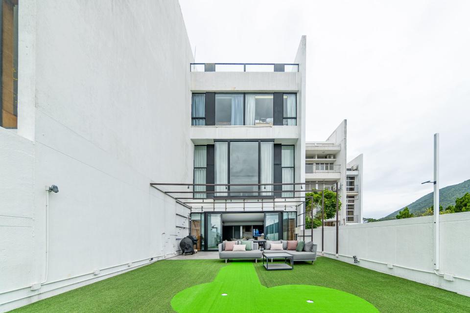 A vibrant strip of green highlights the putting area outside an $82.28 million home in Hong Kong.