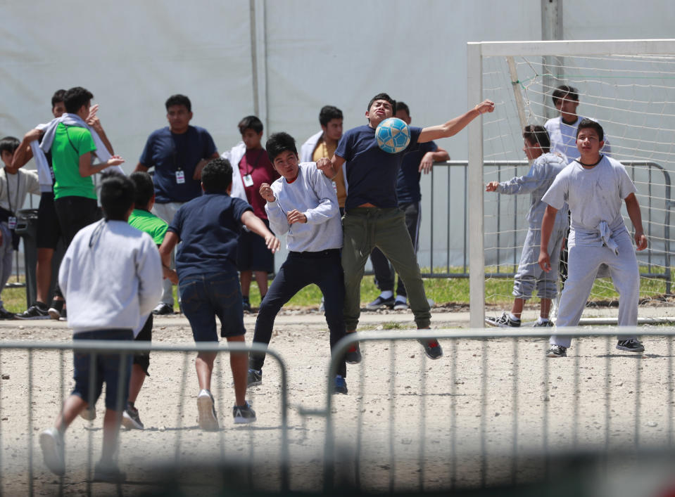 FILE - In this April 19, 2019 file photo, Migrant children play soccer at the Homestead Temporary Shelter for Unaccompanied Children on Good Friday in Homestead, Fla. Immigrant advocates say the U.S. government is allowing migrant children at a Florida facility to languish in “prison-like conditions” after crossing the U.S.-Mexico border instead of releasing them promptly to family as required by federal rules. A court filing Friday, May 31, 2019 revealed conditions inside the Homestead, Florida, facility that has become the nation’s biggest location for detaining immigrant children. (AP Photo/Wilfredo Lee, File)