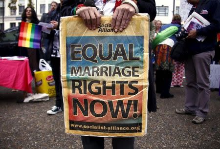 File photo: A gay rights activist holds a placard during a rally supporting same-sex marriage, in Sydney, Australia May 31, 2015. REUTERS/David Gray