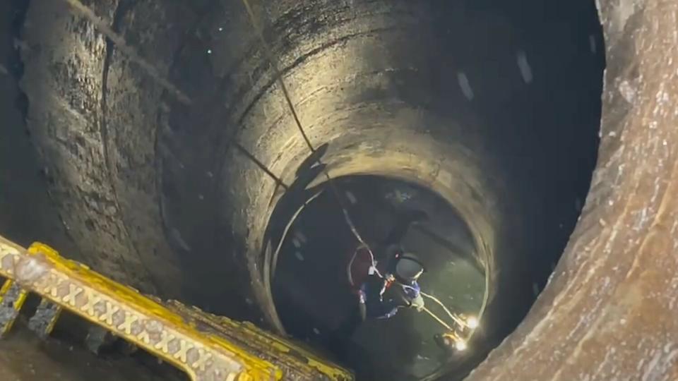 污水人孔內部空間狹小、水流湍急，操作員需積極克服才能完成設置並撤離。   圖：新北市水利局提供