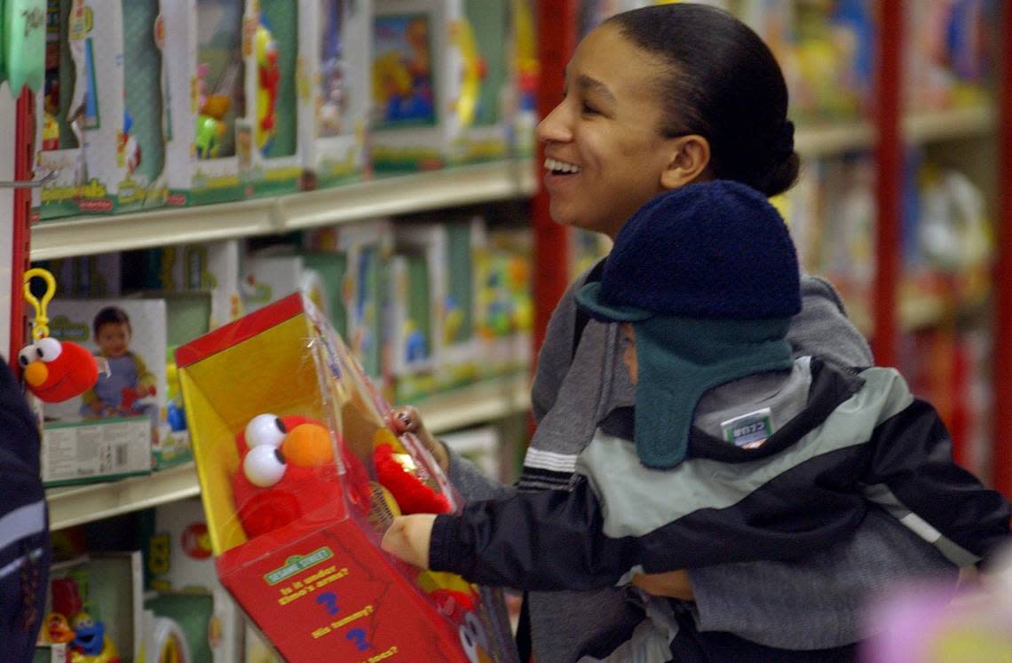 Taniel Washington, with her son 11-month-old son Elijah Muller, picks out an Elmo while Christmas toy shopping at KB Toys on Truxel Road in 2001. Sacramento Bee file