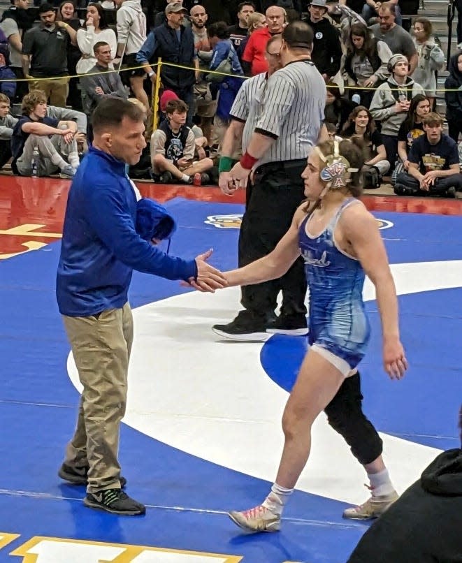 Adam Quitt, left, father and coach of Nora Quitt, greets his daughter after she won the 138-pound title at the New England wrestling championships in Providence on Saturday, March 2, 2024.