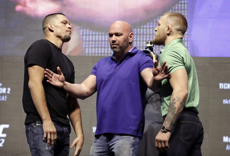 Nate Diaz, left, and Conor McGregor, right, are separated by Dana White. (AP)