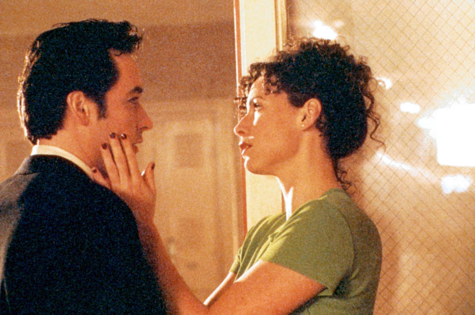 John Cusack's face being held by Minnie Driver.